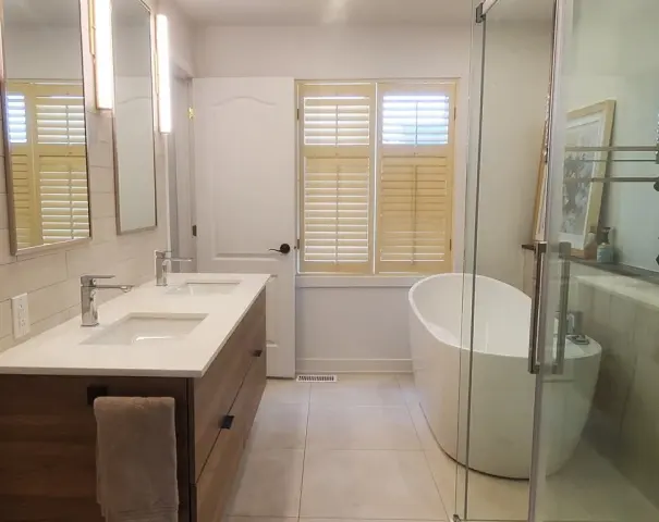 Salle de bain lumineuse avec double vanité et baignoire