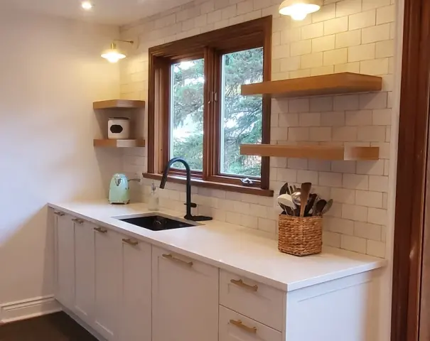 Cuisine blanche avec tablettes de bois et fenêtre au-dessus de l'évier