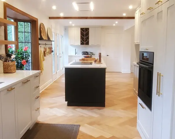 Cuisine avec îlot noir et plancher à chevrons