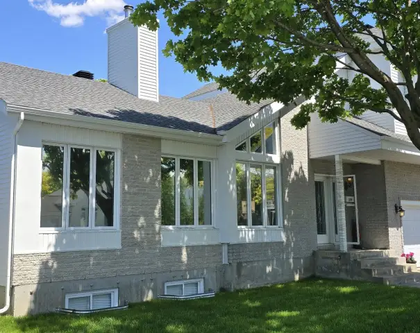 Maison neuve au revêtement clair et grandes fenêtres