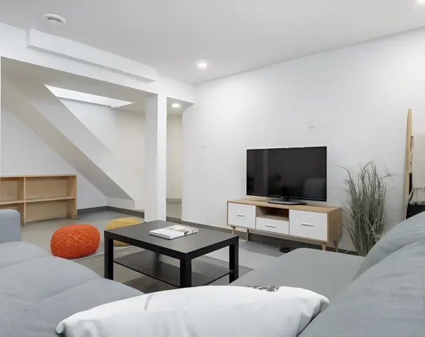 Salon de sous-sol avec téléviseur et coin détente