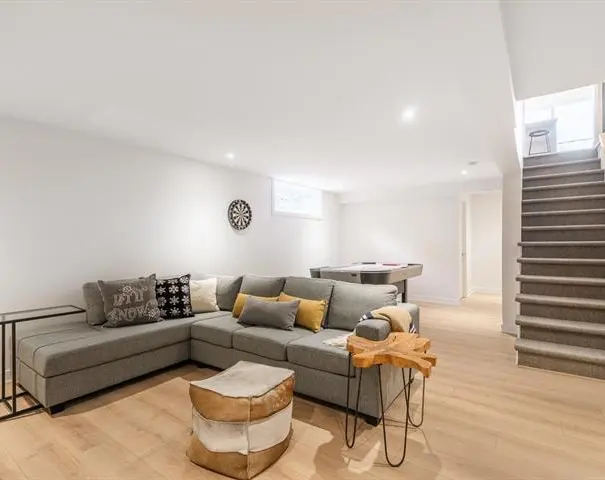 Sous-sol aménagé avec coin salon et escalier