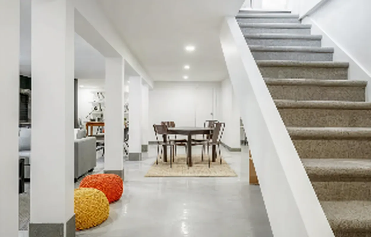 Sous-sol aménagé avec escalier blanc
